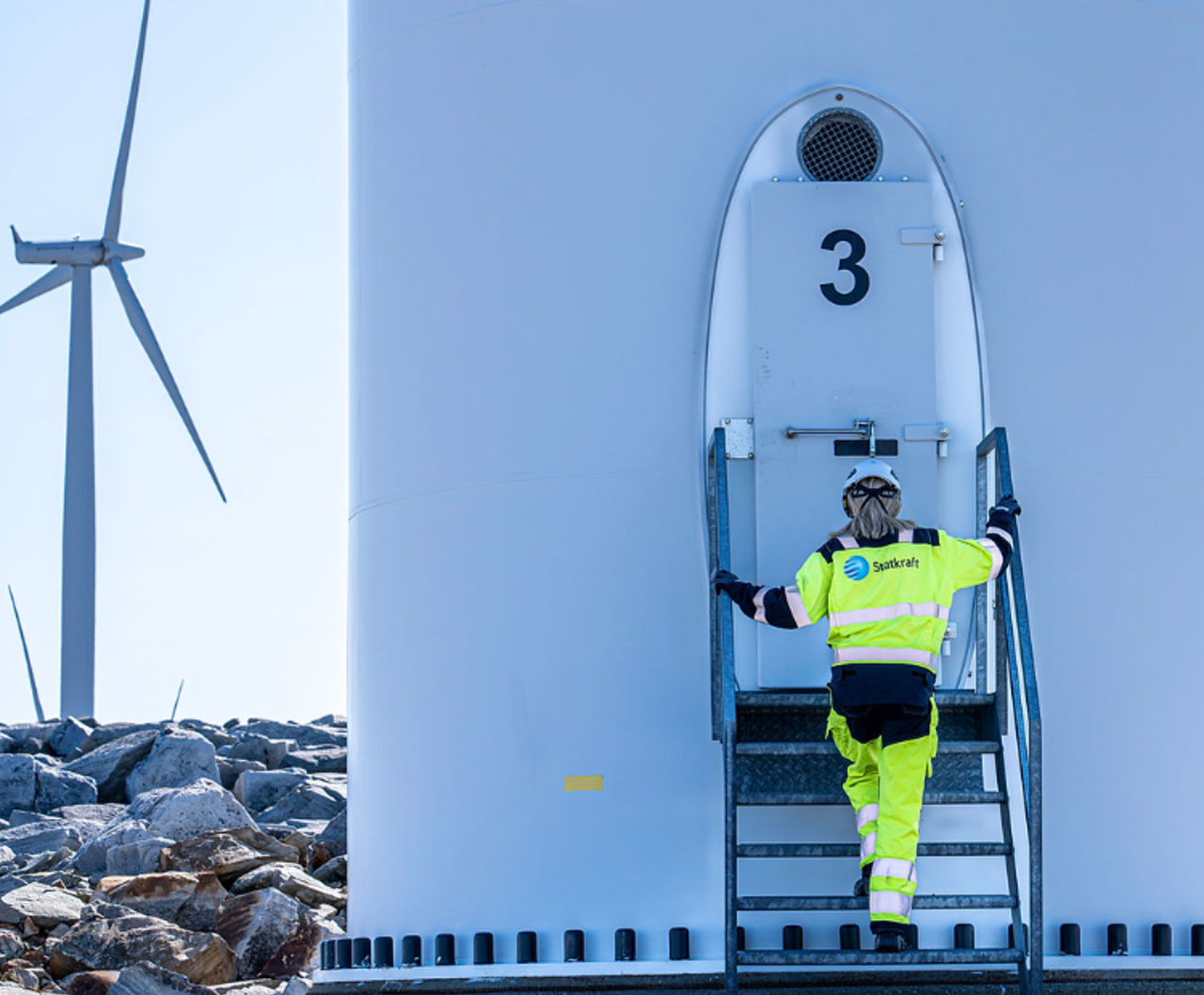 Dame i verneutstyr går inn i en vindmølle
